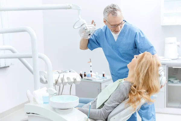 Dentista con paciente en clínica dental - foto de stock