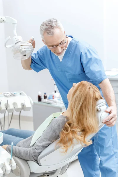 Dentista con paziente in clinica dentistica — Foto stock