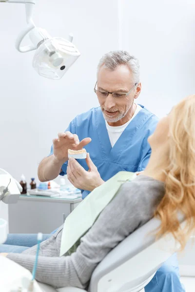 Dentista che mostra modello mascelle — Foto stock