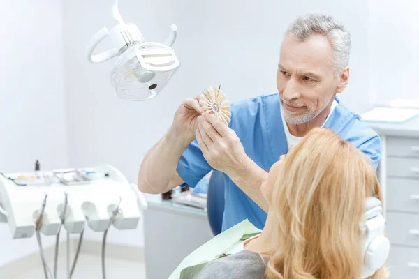 Стоматолог, що відповідає кольору зубів — стокове фото