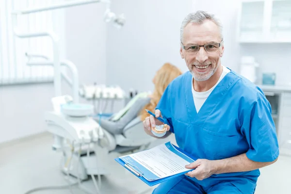 Dentista senior en uniforme - foto de stock