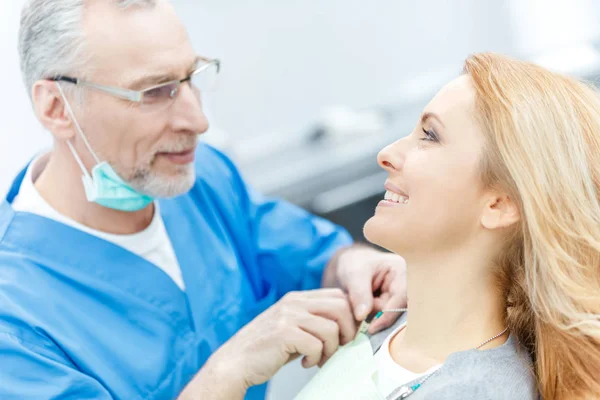 Dentista con paziente in clinica dentistica — Foto stock