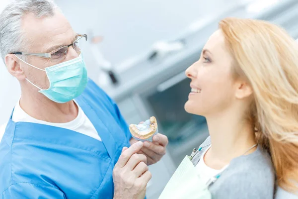 Dentista mostrando modelo de mandíbulas — Fotografia de Stock