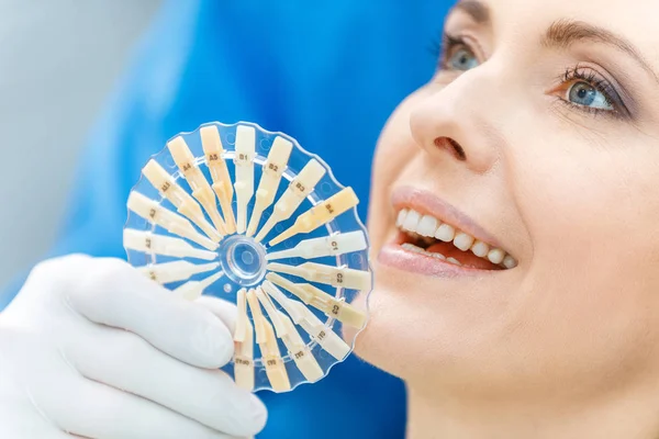 Dentist comparing teeth of patient with samples — Stock Photo