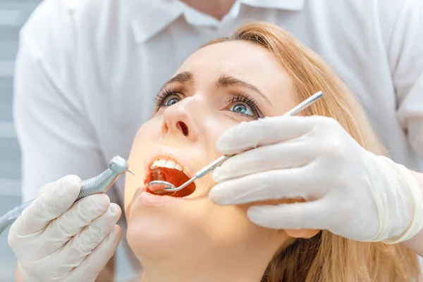 Dentist curing scared patient — Stock Photo