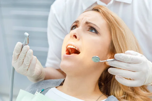 Dentist curing scared patient — Stock Photo