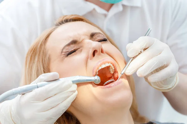 Dentist curing scared patient — Stock Photo