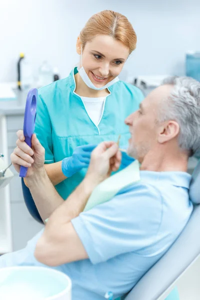 Dentista e paziente in clinica — Foto stock