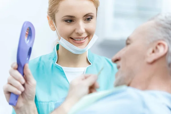 Dentista y paciente en clínica - foto de stock