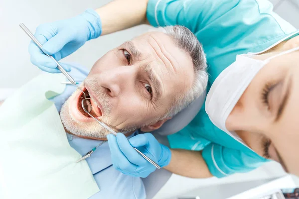 Dentista y paciente en clínica - foto de stock