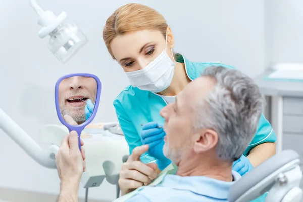 Dentista y paciente en clínica - foto de stock
