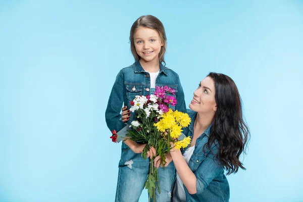 Madre e hija sosteniendo flores - foto de stock