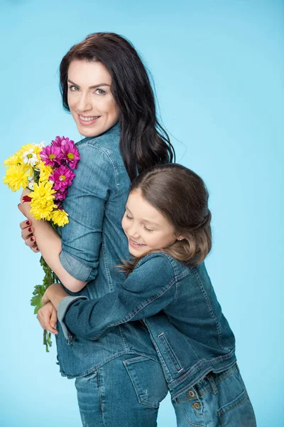 Madre e hija sosteniendo flores - foto de stock