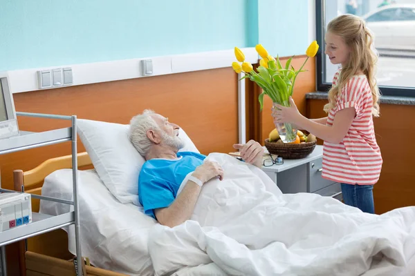 Старший пациент с внучкой — стоковое фото