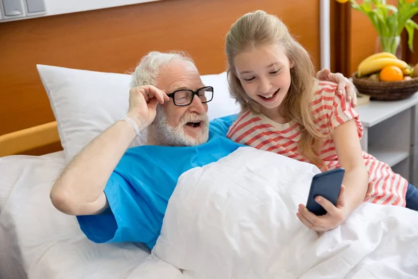 Grandfather and child using smartphone — Stock Photo