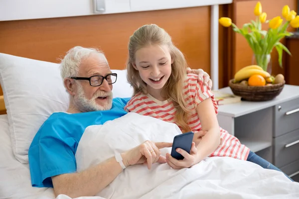 Grandfather and child using smartphone — Stock Photo