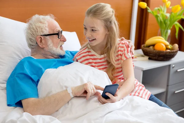 Grandfather and child using smartphone — Stock Photo