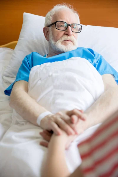 Старший пациент держится за руки — стоковое фото