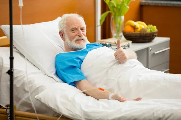 Uomo anziano in letto d'ospedale — Foto stock