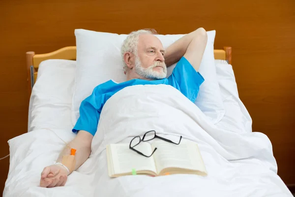 Uomo anziano in letto d'ospedale — Foto stock