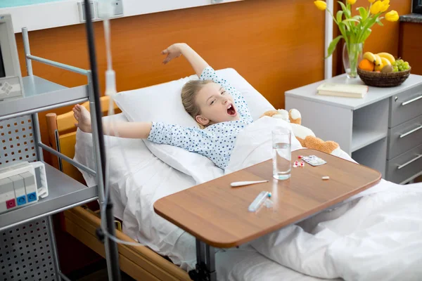 Petite fille dans le lit d'hôpital — Photo de stock