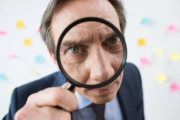 Businessman with magnifying glass — Stock Photo
