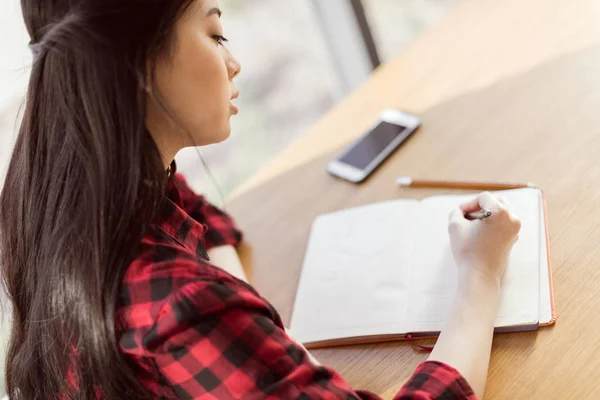 Asian student studying in cafe — Stock Photo