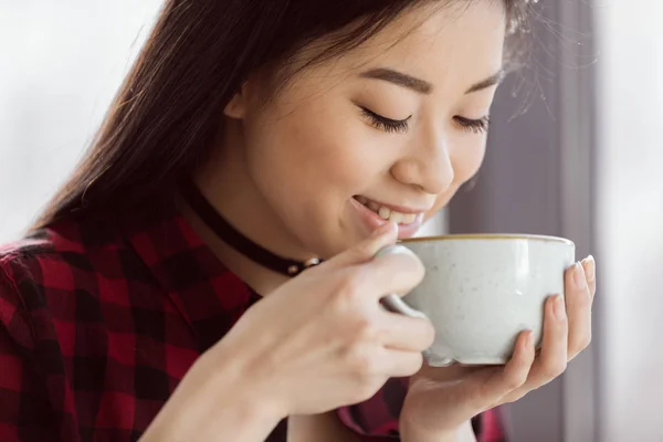 Asian girl drinking coffee — Stock Photo