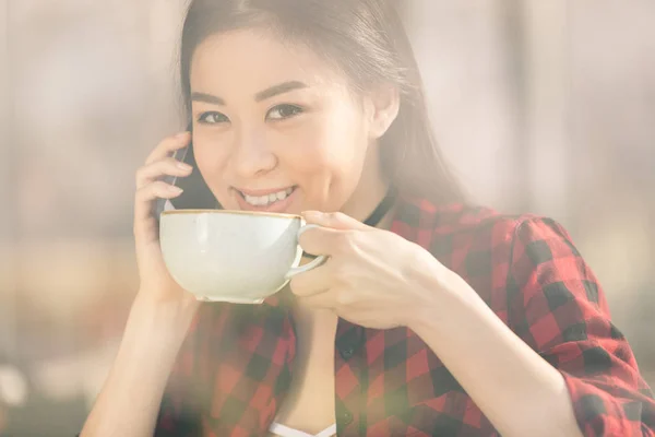 Asian girl drinking coffee — Stock Photo