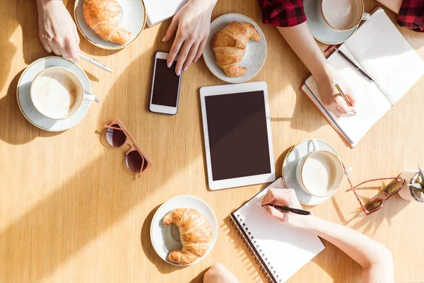 Frauen sitzen mit digitalen Geräten — Stockfoto