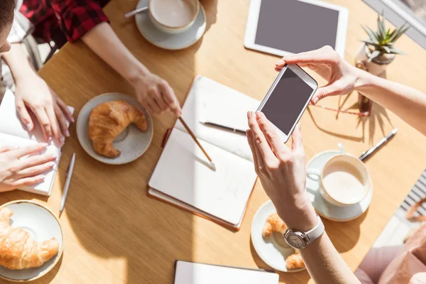 Mujeres sentadas con dispositivos digitales - foto de stock