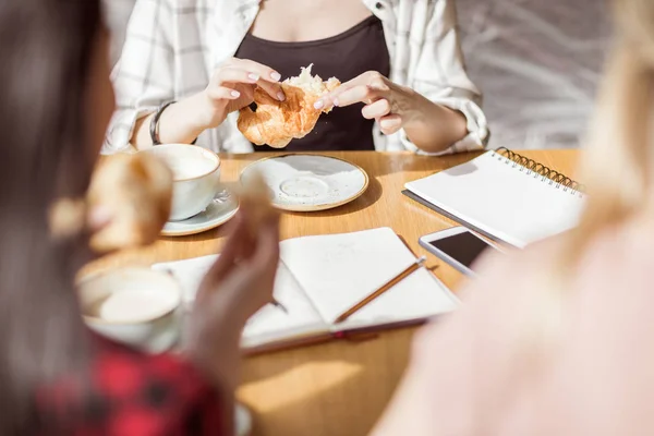 Mädchen essen Croissants und trinken Kaffee — Stockfoto