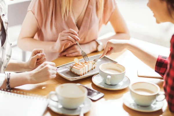 Chicas comiendo pastel y bebiendo café - foto de stock