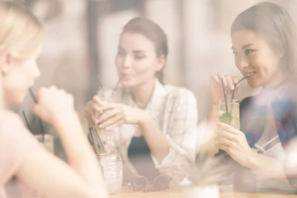 Chicas bebiendo cócteles en la cafetería - foto de stock