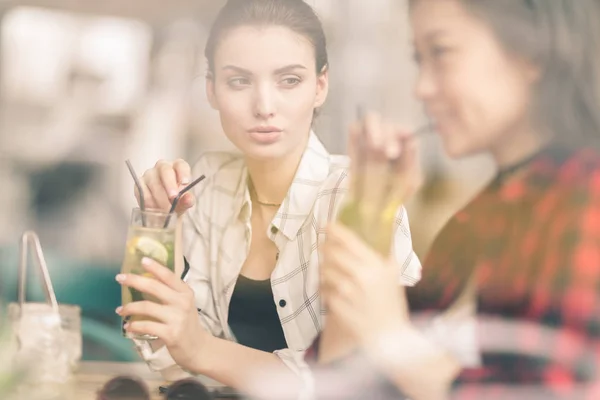 Chicas bebiendo cócteles en la cafetería - foto de stock