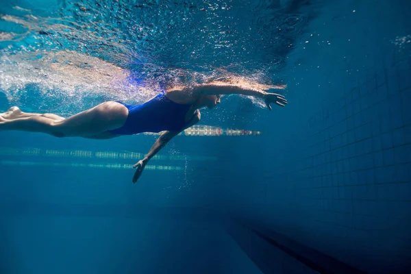 Foto subacquea di una giovane nuotatrice che si allena in piscina — Foto stock