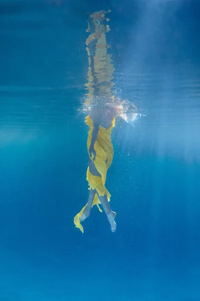 Visão parcial da mulher no vestido nadando subaquático — Fotografia de Stock