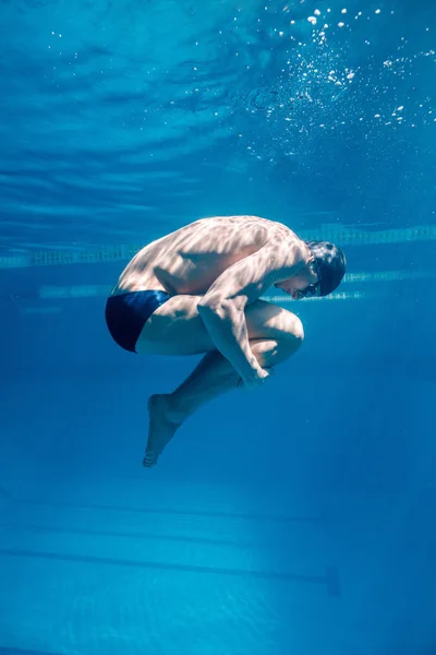 Підводне зображення чоловічого плавця в кепці та окулярах — стокове фото