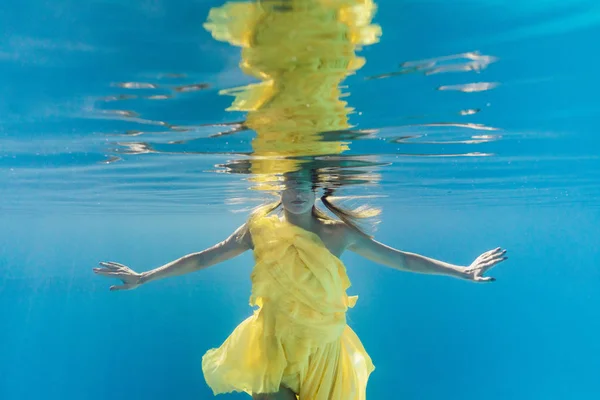 Vista parcial de la mujer en vestido nadando bajo el agua - foto de stock