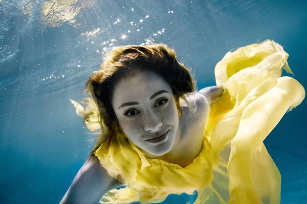 Imagen submarina de la hermosa mujer joven en el vestido de natación en la piscina - foto de stock