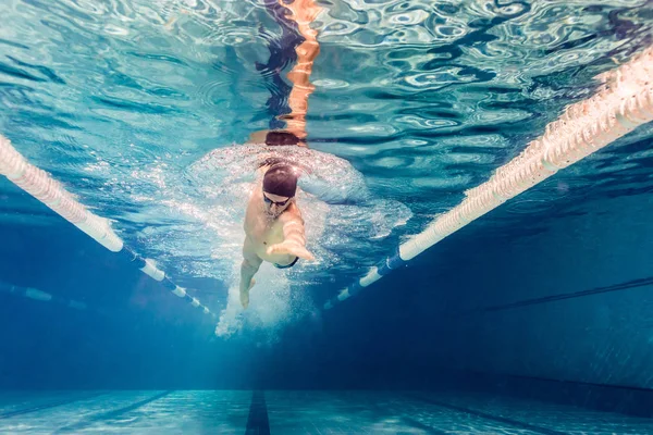 Imagem subaquática do jovem nadador em óculos de exercício na piscina — Fotografia de Stock