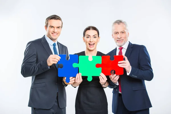 Businesspeople holding puzzle pieces — Stock Photo, Image