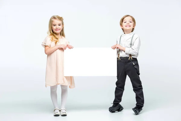 Niños sosteniendo tarjeta en blanco — Foto de Stock