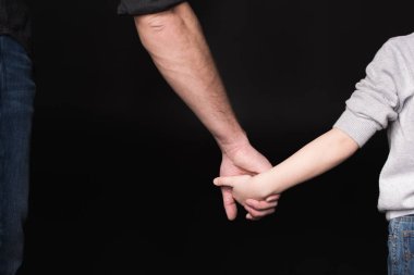 Baba ve çocuk el ele tutuşarak 