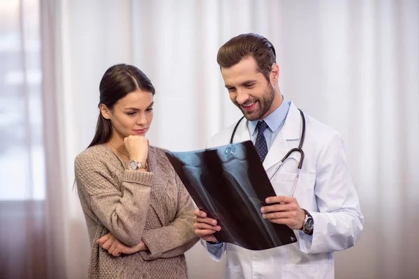 Médico y paciente mirando rayos X — Foto de Stock