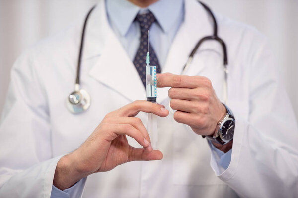 Doctor holding syringe