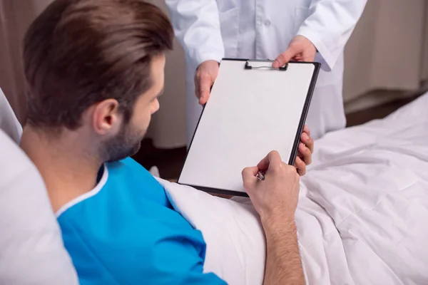 Patient signing medical document — Stock Photo, Image