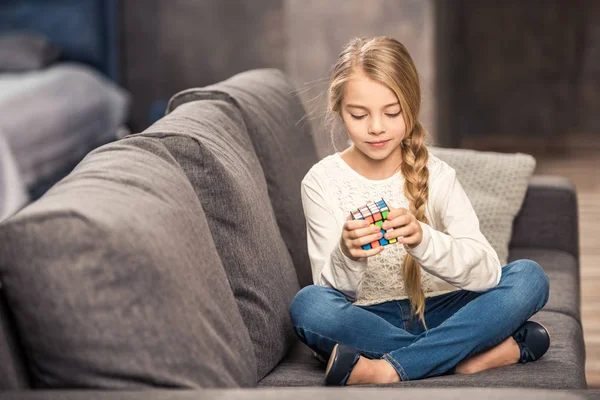 Flicka som leker med Rubiks kub — Stockfoto