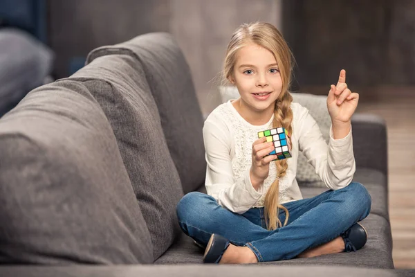 Девушка играет с кубиком Рубика — стоковое фото