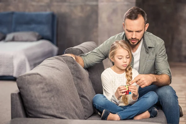 Pai e filha brincando com cubo de rubik — Fotografia de Stock